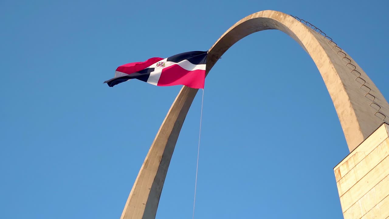 câmera lenta da bandeira da república dominicana acenando sobre o arco triunfal na praça da bandeira