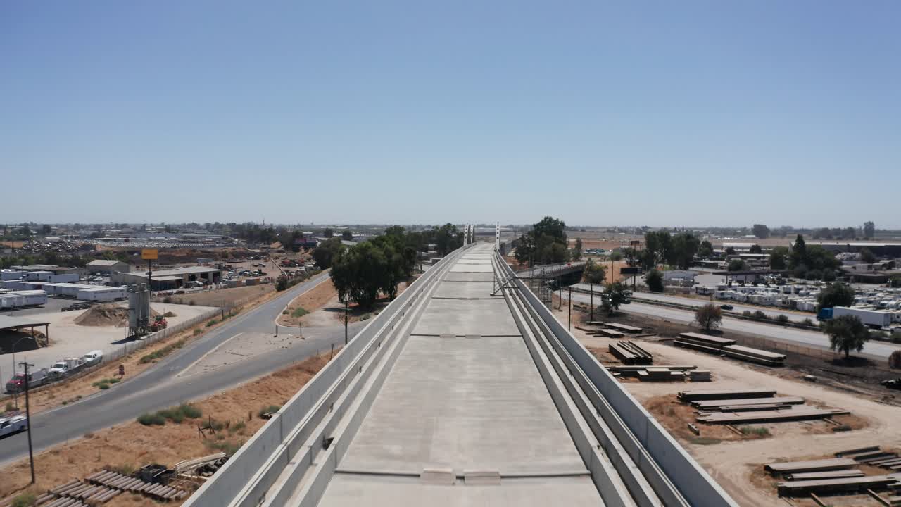 Low close-up aerial shot flying over the unfinished elevated track of the California High-Speed Rail in Fresno, California. 4K