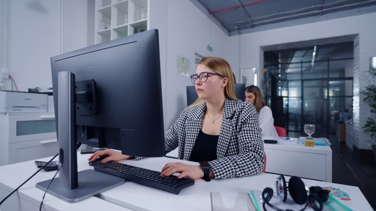 mujer trabajando en una computadora en una oficina moderna