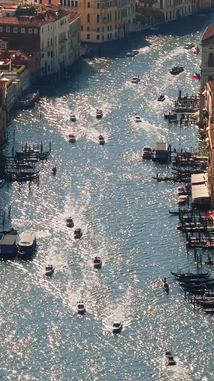Aerial drone view of boats moving through Venice City, Italy on a sunny day. Vertical