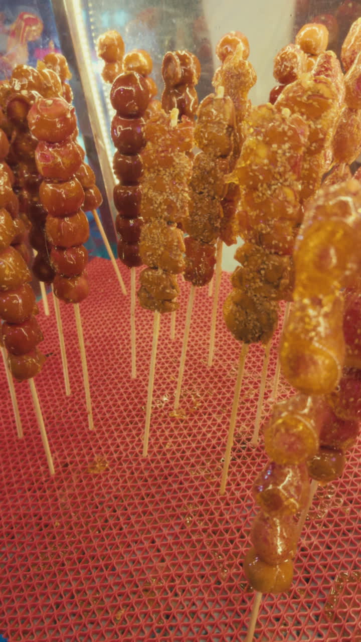 Uno spuntino tradizionale cinese di spiedini di frutta candita in mostra a Wuzhen, Cina
