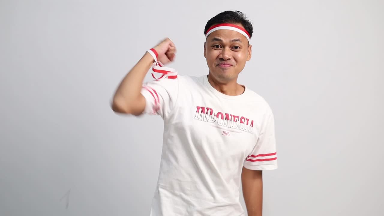 Asian man celebrates Indonesia independence day, showing fist hand isolated over white background