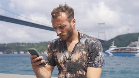 thoughtful and unhappy teenager is using phone. the city strait.