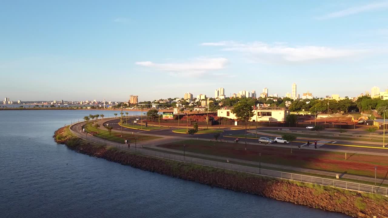 해가 지는 동안 파라나 강을 따라 돌고 있는 대로의 놀라운 공중 촬영