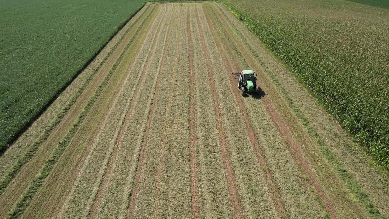 In un campo agricolo nel Wisconsin sud-occidentale, un agricoltore rastrella il fieno usando un ranghinatore rotante per fieno-5