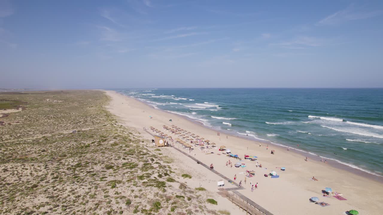 playa de la isla de culatra en portugal con bañistas y paraguas bajo un cielo despejado, vista aérea