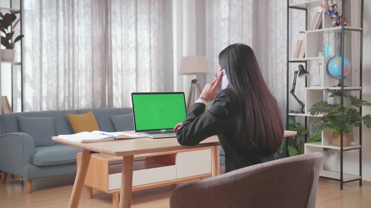 집에서 노트북으로 전화를 하는 사업가