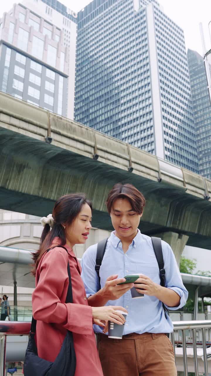 Couple with coffee and smartphone in city