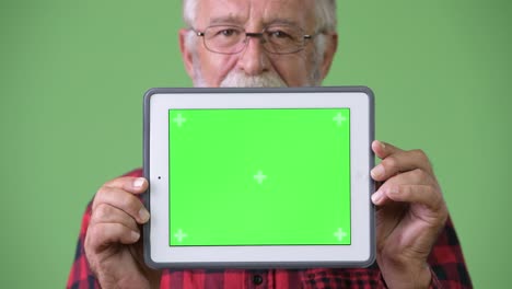 hombre de barba viejo y guapo contra un fondo verde.