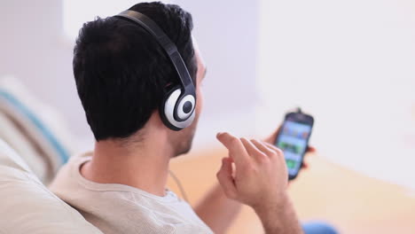 Un-Hombre-Guapo-Escuchando-Música-En-Su-Teléfono-Inteligente.