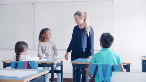 Primary-school-teacher-asking-questions-to-female-student