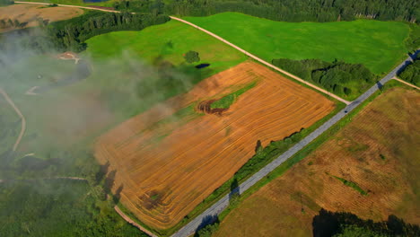 Drone-aerial-landscape-view-of-smoke-fire-back-burning-crops-in-field-farmland-agriculture-harvest-industry-rural-town-suburbs-with-road-street-countryside-neighborhood