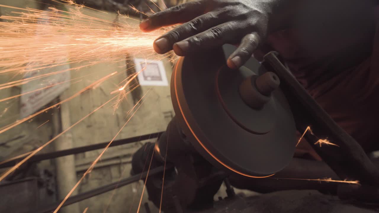 Grindstone sharpening wheel tool in use by indian blacksmith
