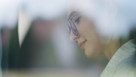 primer plano de la cara de la mujer pensando a través de la ventana de la oficina