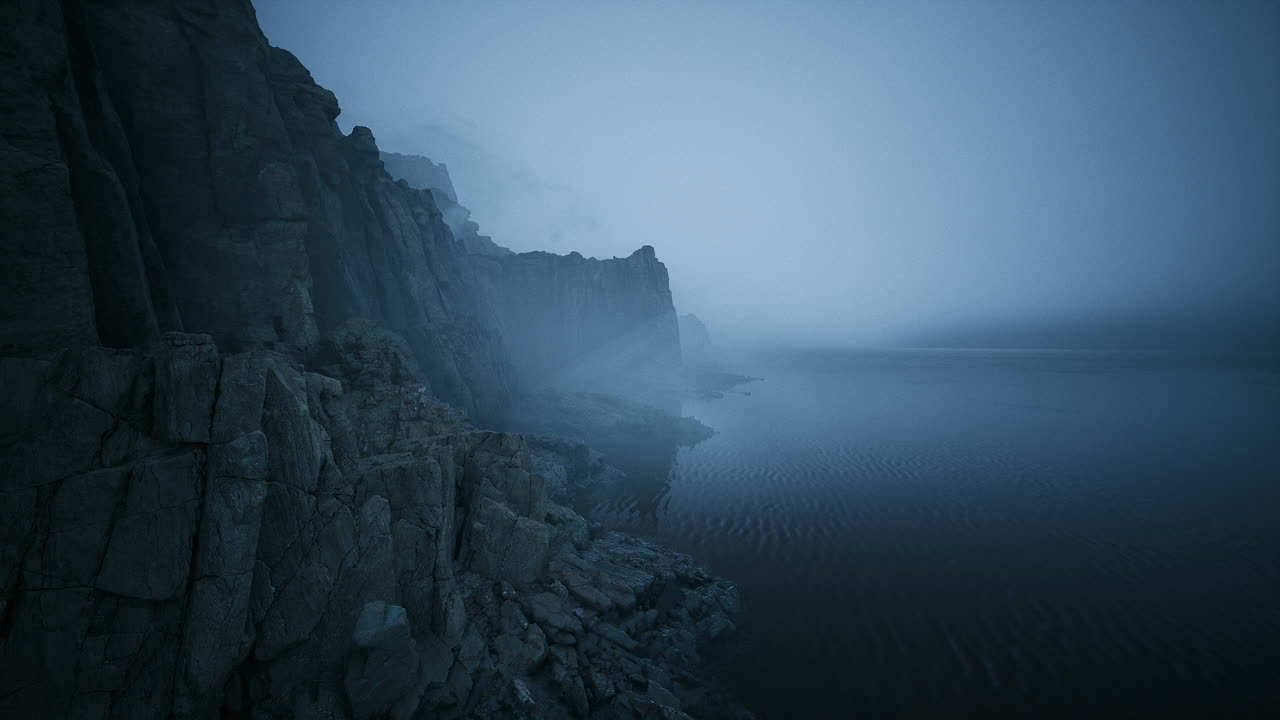 Coastal cliffs shrouded in fog over calm waters at twilight