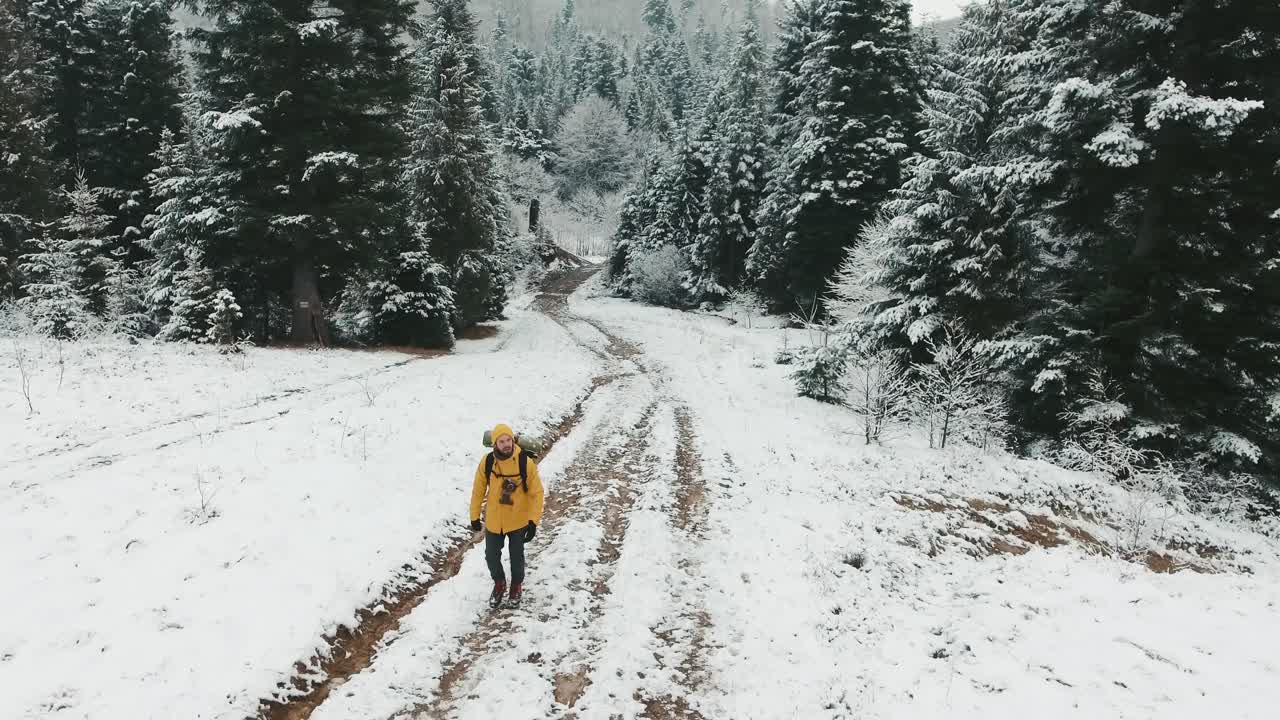Homem caminhando pela floresta nevada no inverno