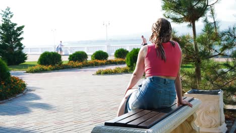 woman sitting on a bench in a park by the sea