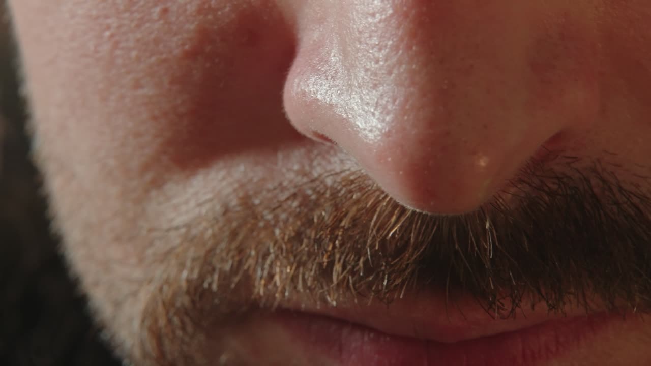 primer plano de un macho recogiendo el cabello nasal con pinzas