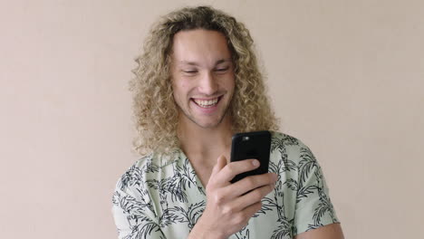 portrait of attractive young man laughing using phone browsing social media