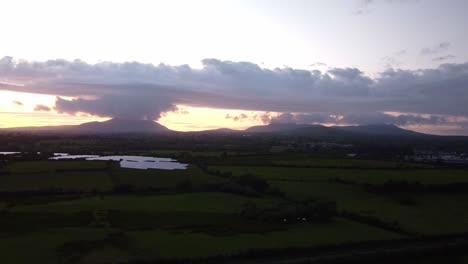 aerial 4k drone footage of the sun setting and clouds over the hills of north wales