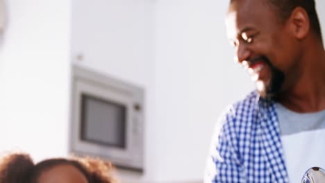 Father-and-daughter-giving-high-five-in-kitchen