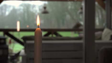 vela ardiendo con jardín en el fondo