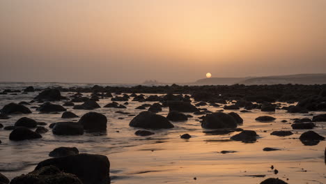 Timelapse-of-sea-waves-on-coast-with-rocks-at-sunset