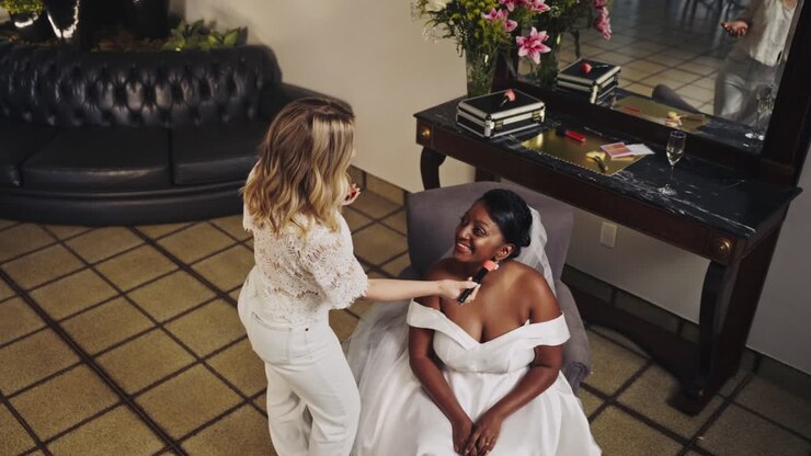 A bride getting her makeup done by a makeup artist on her wedding day