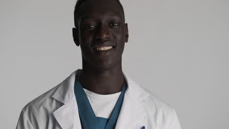 happy african american doctor on grey background.
