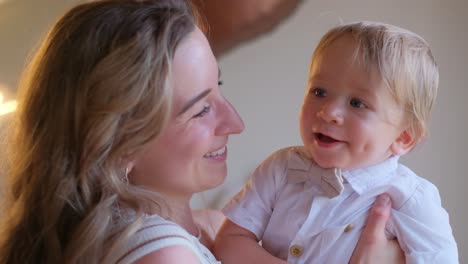 a blonde woman holding a baby both smiling and sharing a happy moment a woman is happily holding a smiling baby in her arms showcasing joy and love