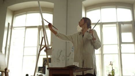 inspired woman creating painting indoors