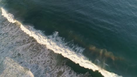 Aerial-cinematic-shot-a-wave-breaking-and-splashing-in-the-morning,-Zicatela-beach,-Puerto-Escondido,-Oaxaca