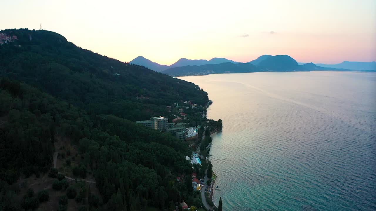 Sunset on the Greek coast. The sea, mountains in the background, some buildings can be seen