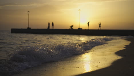 people on a pier at sunset