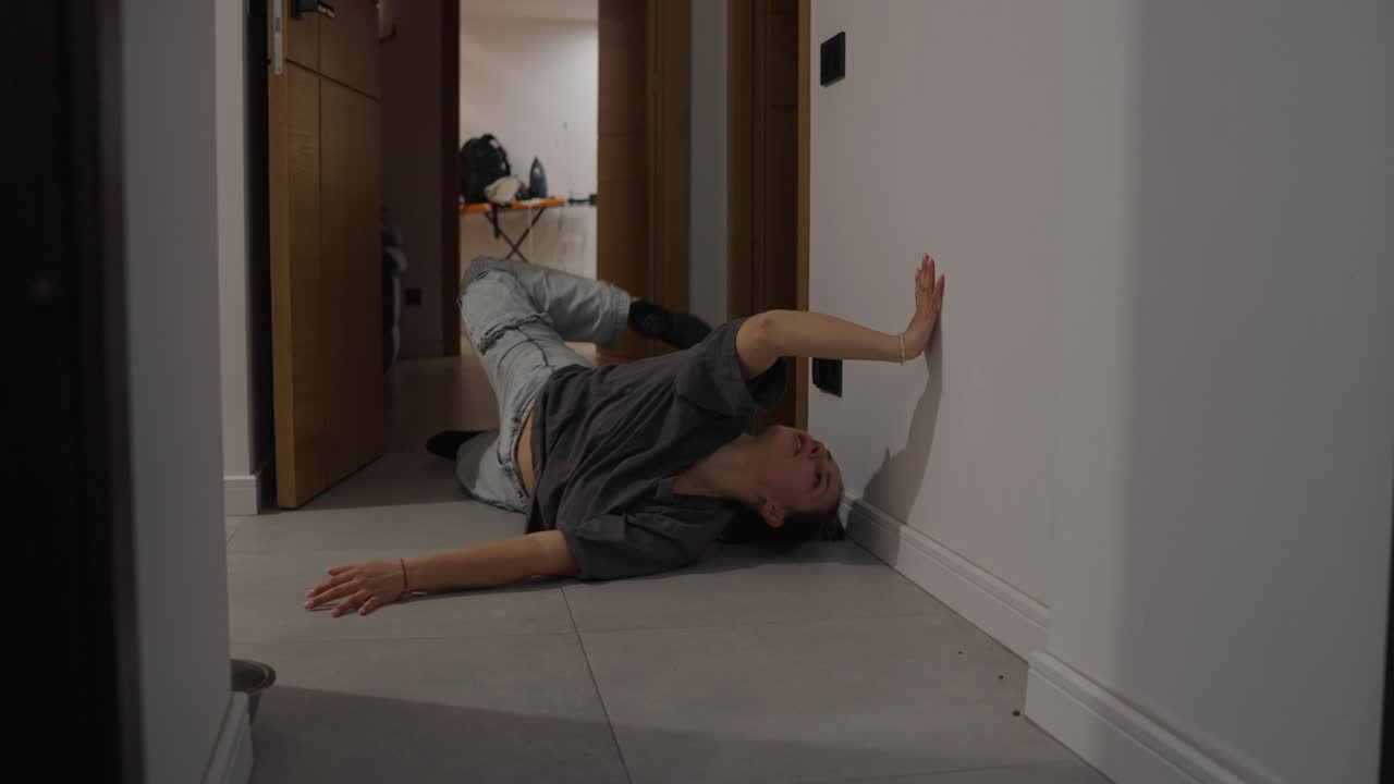 Woman lying on the floor in a hallway