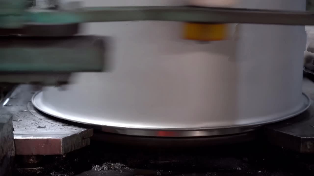 An automated machining process shapes the underside of the drum lid