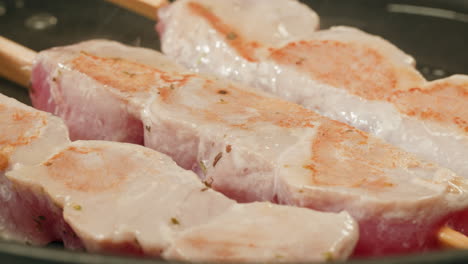 cooking tuna skewers in a pan