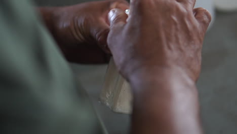 Slow-motion-footage-of-male-African-American-hands-packaging-a-bar-of-soap