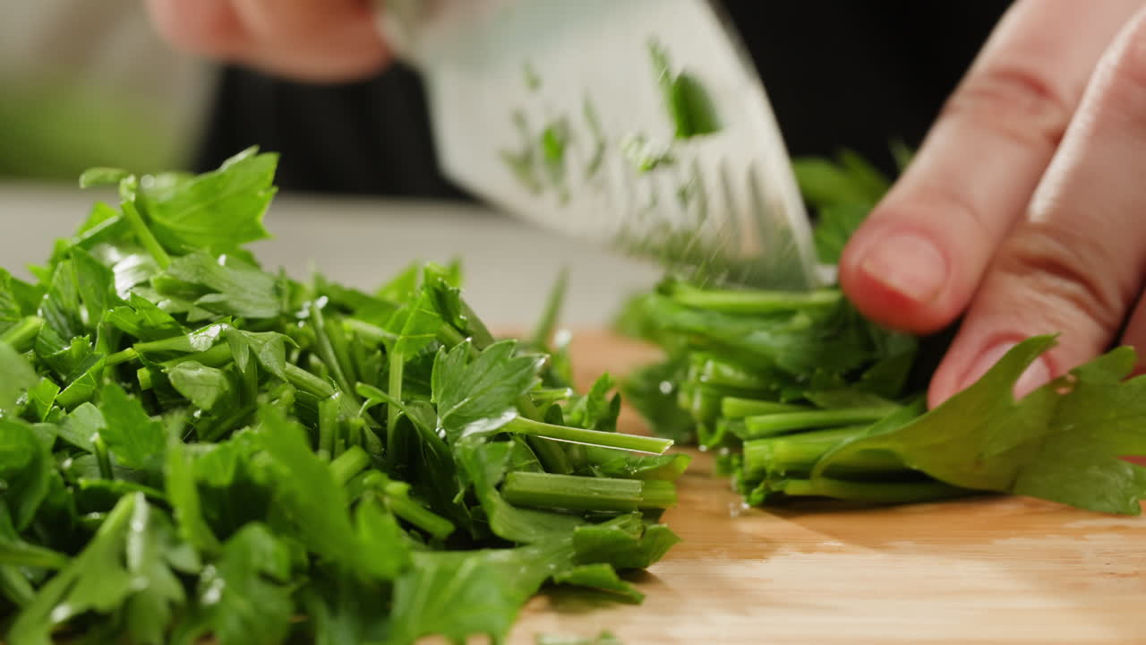 Cilantro parsley cutting by knife close up, chef chop cut coriander aromatic, traditional asian and Mexican cuisine herb studio shot. High quality 4k footage