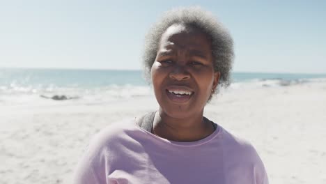 portrait of happy senior african american woman smiling at beach, in slow motion