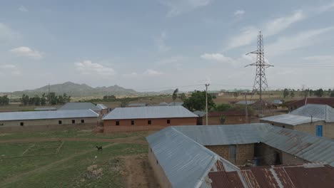 Luftaufnahme---Drohnenpanorama-Eines-Nigerianischen-Dorfes-Mit-Stromleitungen-Am-Tag