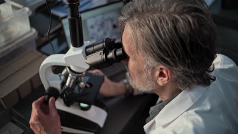 scientist working with microscope and computer