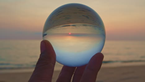 magic sunset view in a crystal ball on your hand.