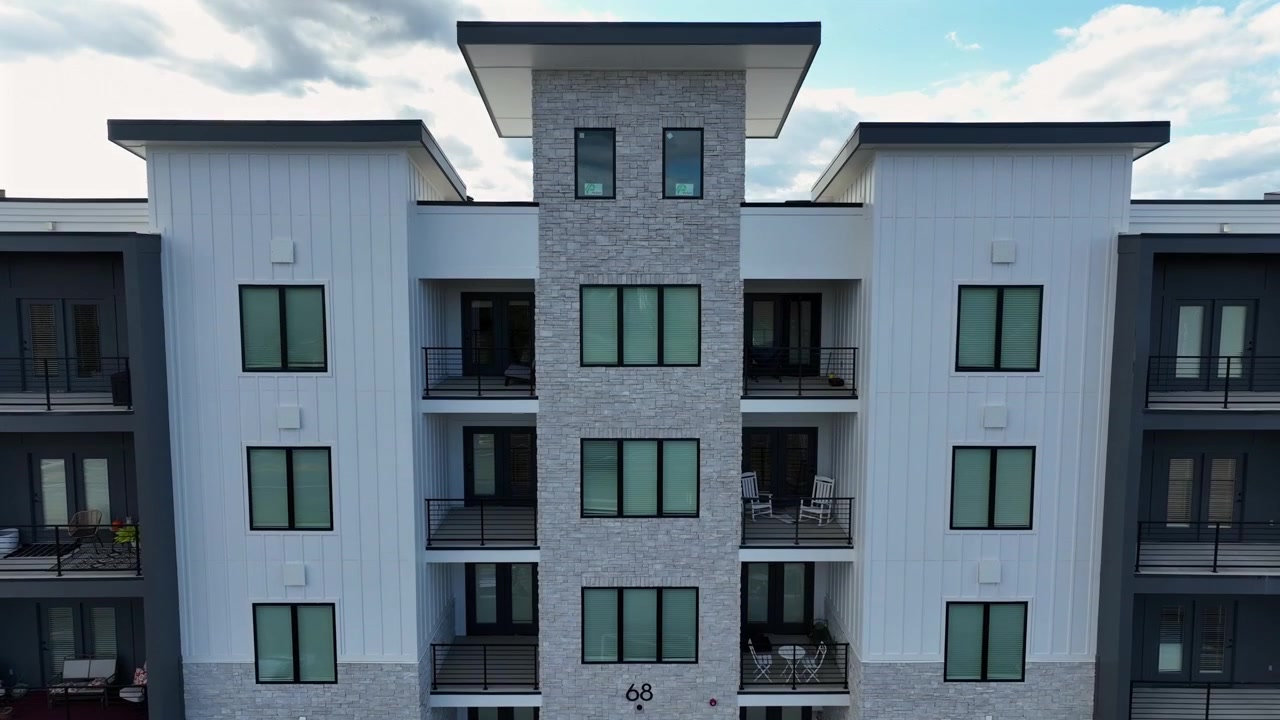Moderne hus med balkon i en forstad til en amerikansk by. Parkerede biler foran bygningen. Stigende drone-vidvinkeloptagelse på en solrig efterårsdag. PA, USA.