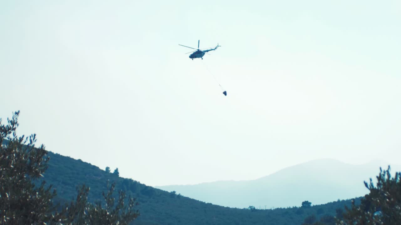 산불에 물을 떨어뜨린 후 멀리 날아가는 헬기