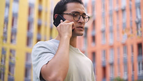 Serious-Young-Japanese-Man-Talking-On-The-Mobile-Phone-While-Standing-Outdoors-In-The-Street-3