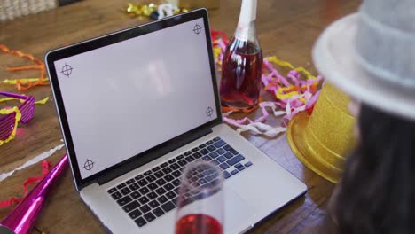 feliz mujer biracial haciendo video llamada de año nuevo, en una computadora portátil con espacio de copia