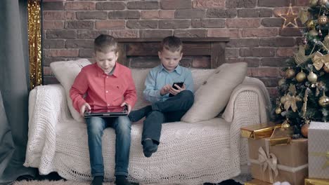 schoolkids sit on sofa share impressions about tablet games