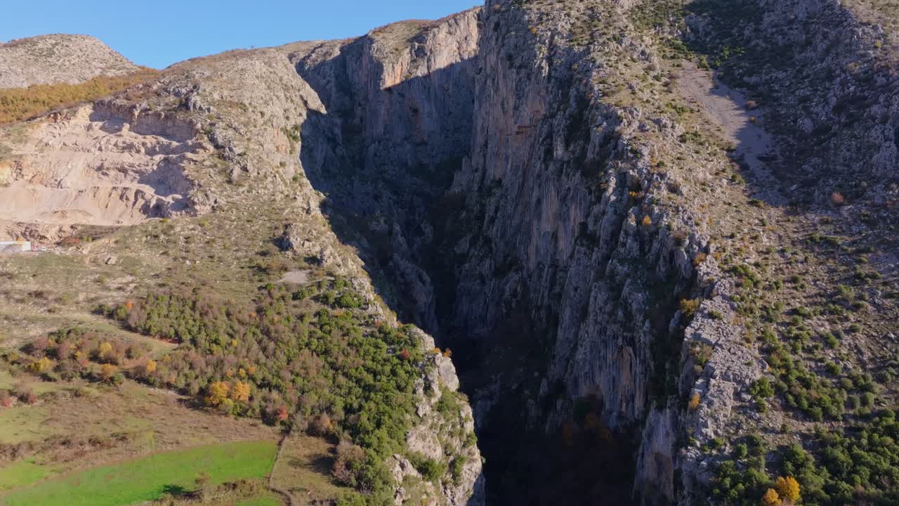 Filmato da drone di un profondo canyon con vegetazione lussureggiante e terreno accidentato, Albania.