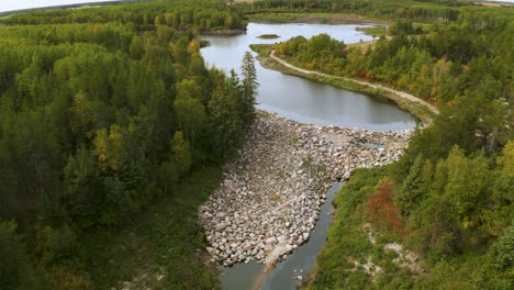 a natural looking man made rock dam holding back water from a small creek